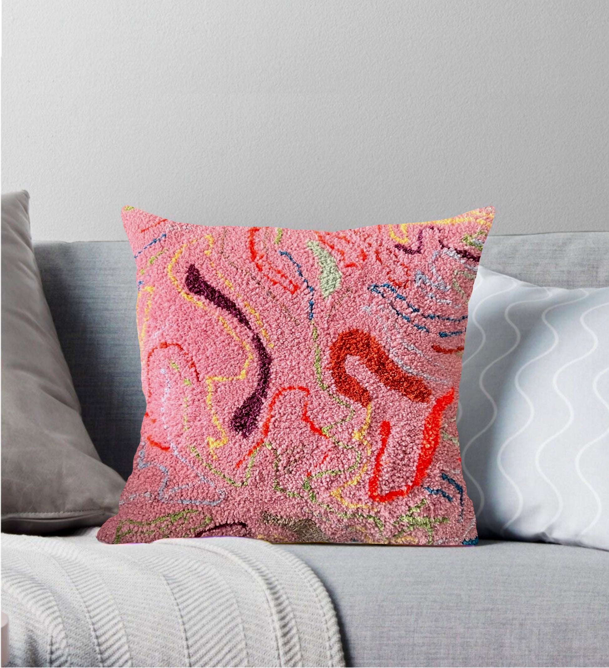 Pembe tonlarda, kıvrımlı desenli el yapımı tufting yastık.
