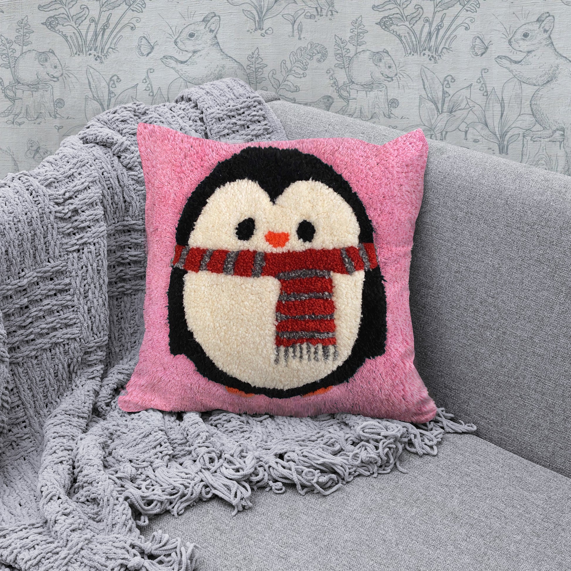 Pembe zeminli, atkılı penguen figürlü sevimli tufting yastık.